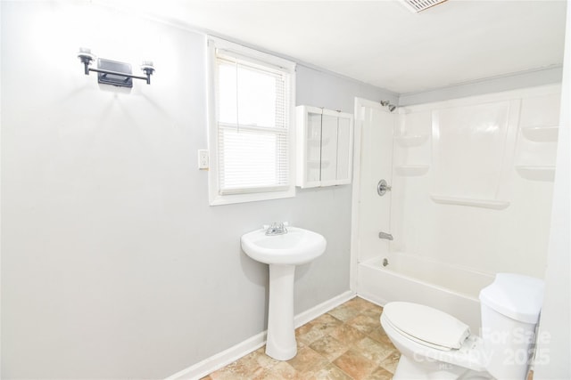 bathroom with toilet, bathing tub / shower combination, and baseboards