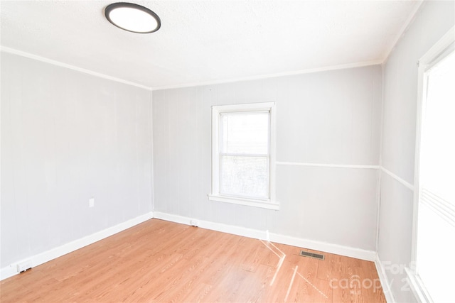 empty room with baseboards, wood finished floors, and a healthy amount of sunlight