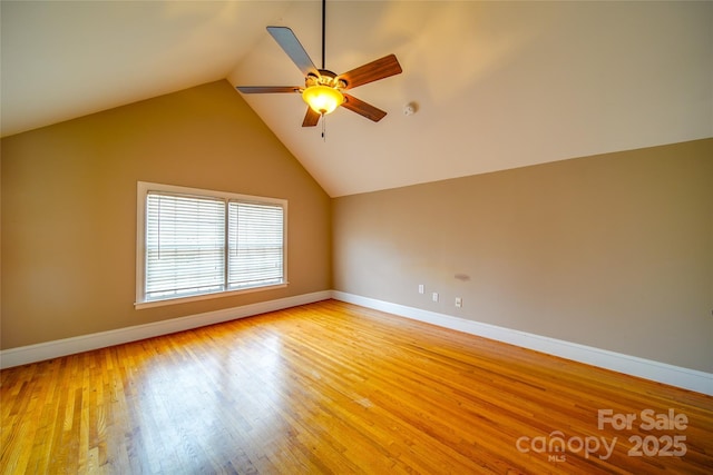 spare room with a ceiling fan, lofted ceiling, baseboards, and light wood finished floors