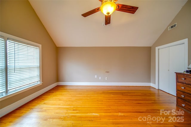 bonus room with light wood-type flooring, baseboards, visible vents, and vaulted ceiling