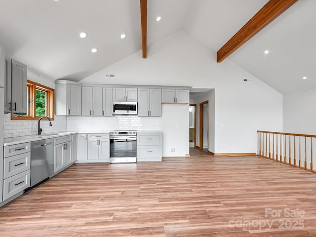 kitchen featuring appliances with stainless steel finishes, light wood-type flooring, gray cabinets, and light countertops