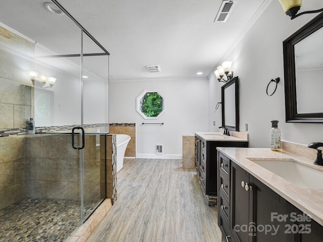 full bath with ornamental molding, a stall shower, visible vents, and a sink