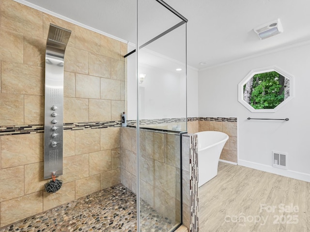 full bath featuring visible vents, a freestanding bath, ornamental molding, a shower stall, and wood finished floors