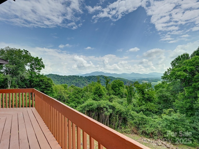 wooden terrace with a mountain view and a view of trees