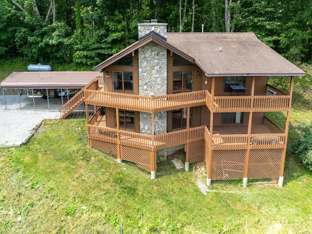 back of house with driveway, a shingled roof, a deck, and a yard