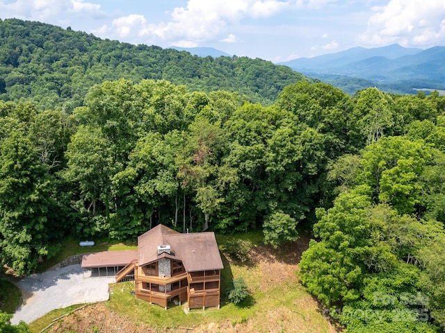 birds eye view of property featuring a forest view and a mountain view