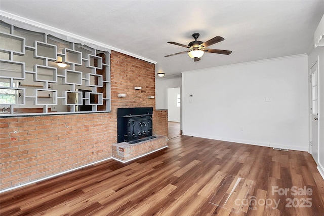 unfurnished living room with ornamental molding, ceiling fan, and wood finished floors