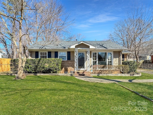 single story home with brick siding, a front lawn, and fence