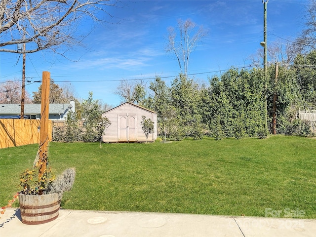 view of yard with an outbuilding, a shed, and fence