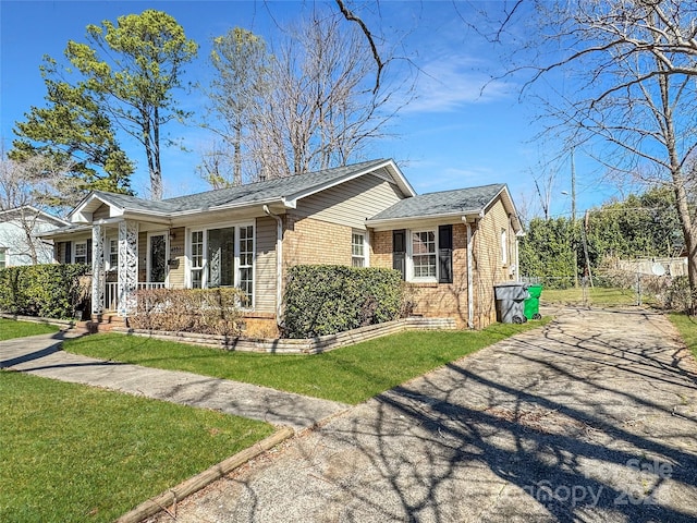 view of side of home featuring brick siding and a lawn