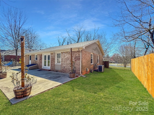 back of house with central AC, brick siding, fence, french doors, and a patio area