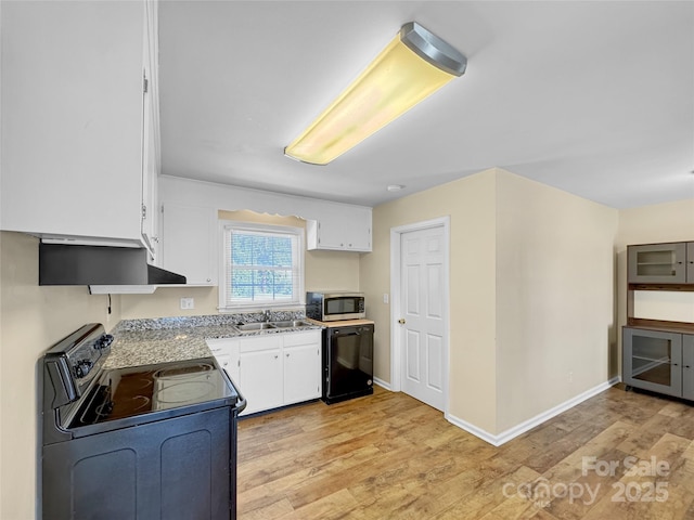 kitchen featuring black appliances, light wood-type flooring, a sink, and white cabinetry