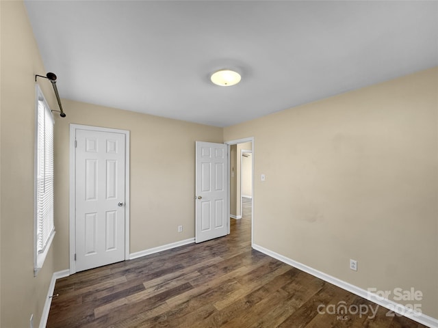 unfurnished bedroom with baseboards and wood finished floors