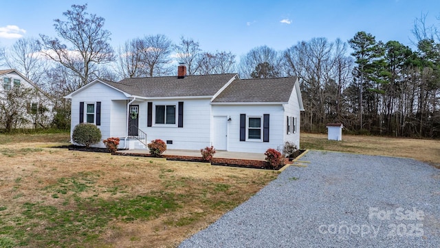 single story home featuring driveway, a chimney, roof with shingles, crawl space, and a front lawn