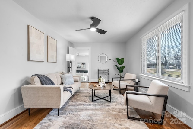 living area featuring ceiling fan, wood finished floors, and baseboards