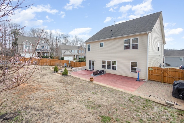 rear view of property with a patio and a fenced backyard