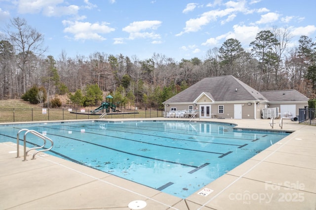 community pool with fence, french doors, playground community, and a patio