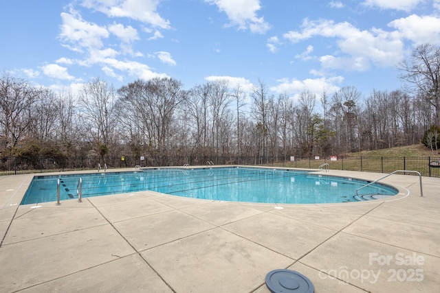 community pool with fence and a patio