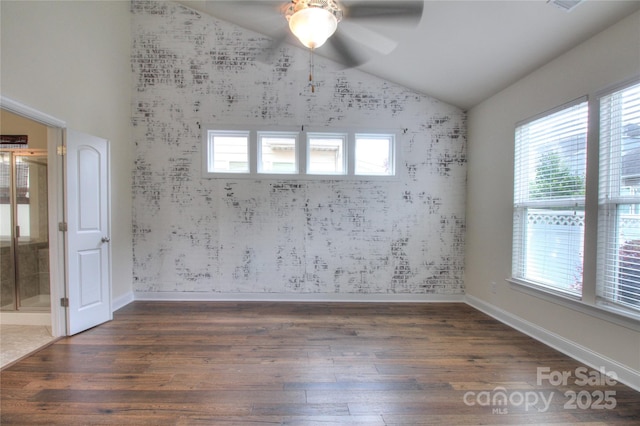 unfurnished room featuring vaulted ceiling, wood finished floors, a wealth of natural light, and ceiling fan