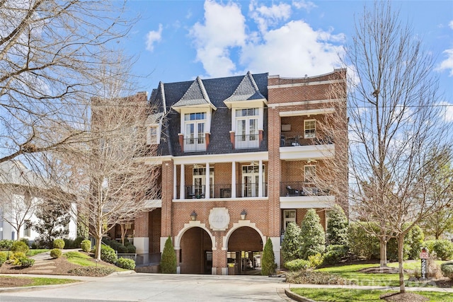 shingle-style home featuring brick siding