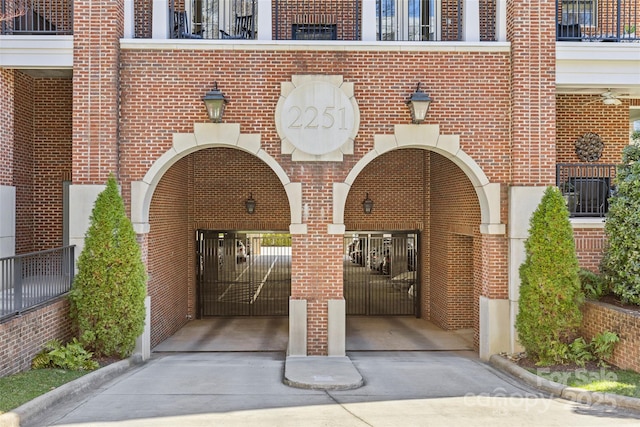 entrance to property with concrete driveway and brick siding