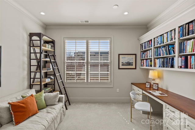 carpeted home office with ornamental molding, visible vents, baseboards, and built in study area