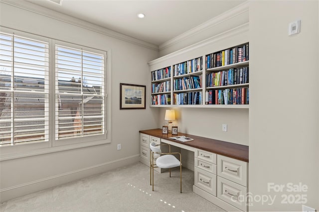 home office featuring light carpet, ornamental molding, built in study area, and baseboards