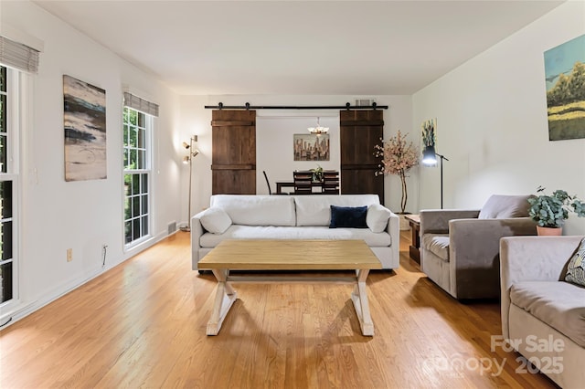 living room featuring light wood-style flooring and a barn door