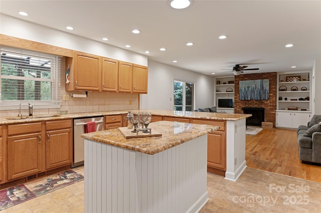 kitchen featuring open floor plan, stainless steel dishwasher, a kitchen island, and a wealth of natural light