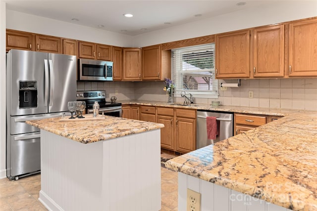 kitchen with stainless steel appliances, recessed lighting, backsplash, a sink, and light stone countertops