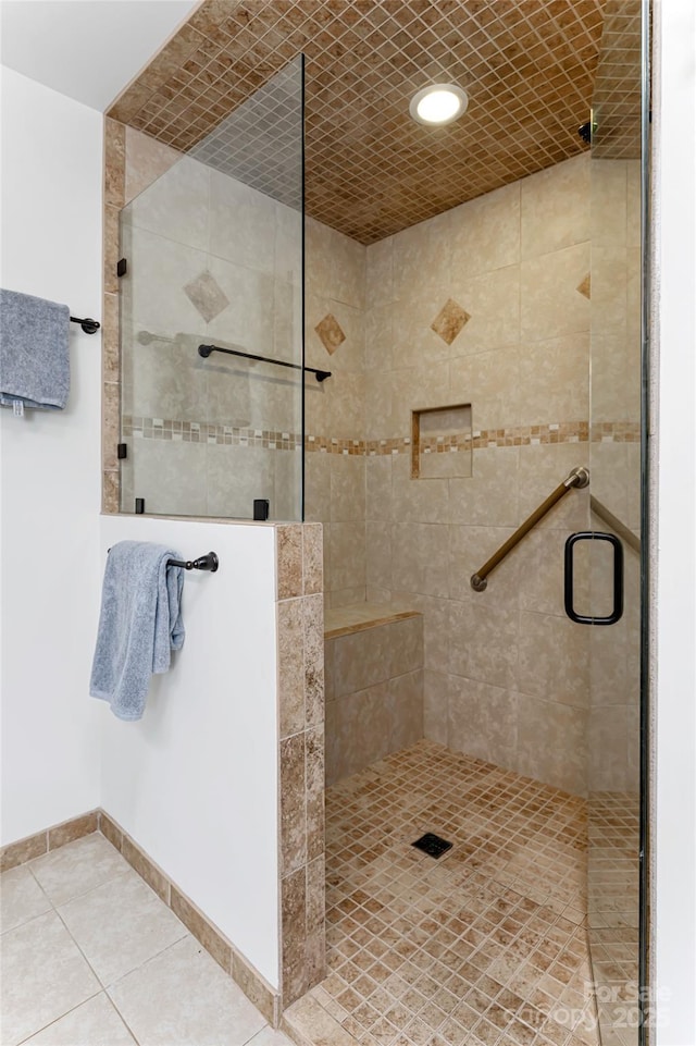 full bathroom with a stall shower, baseboards, and tile patterned floors