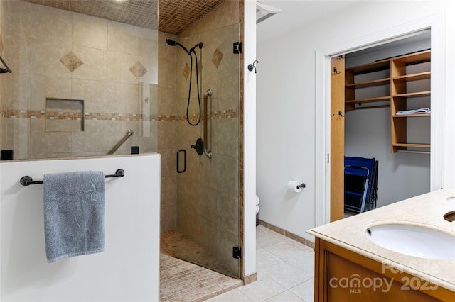 full bathroom featuring tile patterned flooring, a shower stall, and vanity