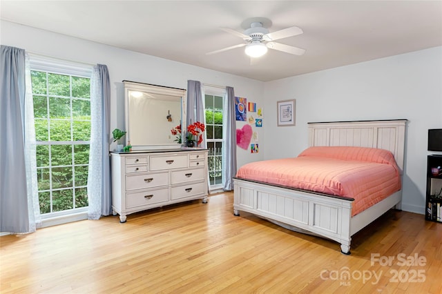 bedroom featuring multiple windows, light wood-type flooring, and a ceiling fan