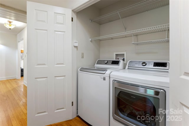 laundry room featuring light wood-style floors, washer and dryer, laundry area, and baseboards