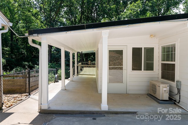 view of patio / terrace featuring ac unit, fence, and a carport