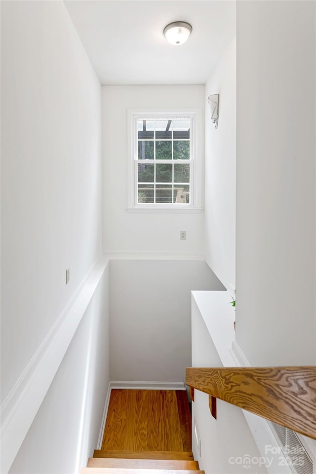 stairs featuring wood finished floors and baseboards