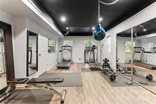 exercise room with baseboards and wood finished floors