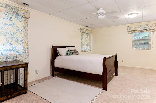 bedroom featuring ceiling fan, carpet floors, a drop ceiling, and baseboards