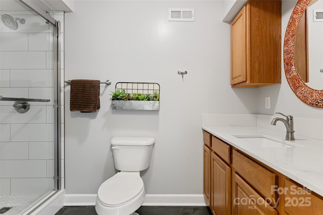 bathroom with toilet, a stall shower, baseboards, and visible vents