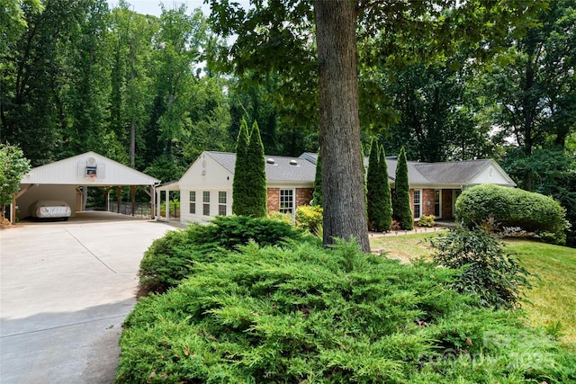 view of front of house featuring a carport, concrete driveway, and brick siding