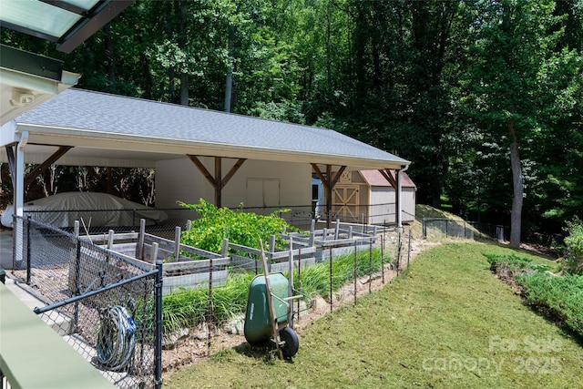 view of home's community featuring a yard, fence, a vegetable garden, and an outdoor structure