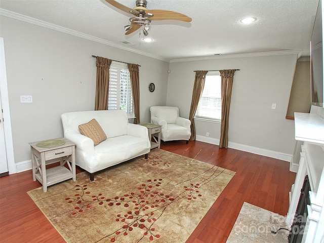 sitting room featuring a textured ceiling, ornamental molding, and wood finished floors