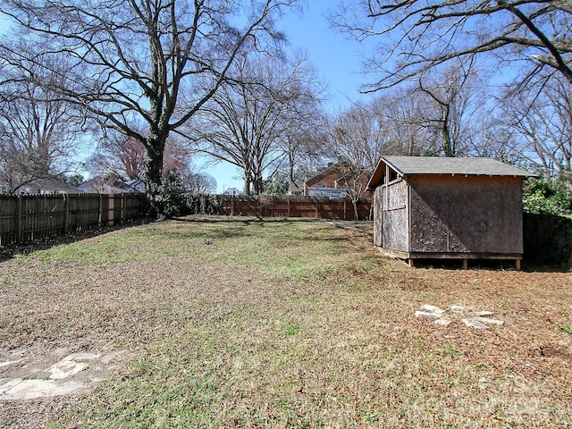 view of yard featuring a fenced backyard, an outdoor structure, and a storage unit