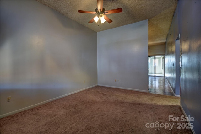 carpeted spare room featuring ceiling fan, baseboards, and a textured ceiling