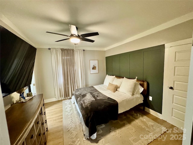 bedroom with light wood-style floors and a ceiling fan