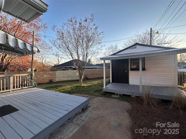 wooden deck featuring fence, a lawn, and an outdoor structure