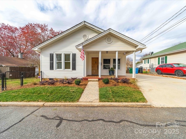 bungalow-style house with a gate, fence, covered porch, concrete driveway, and crawl space