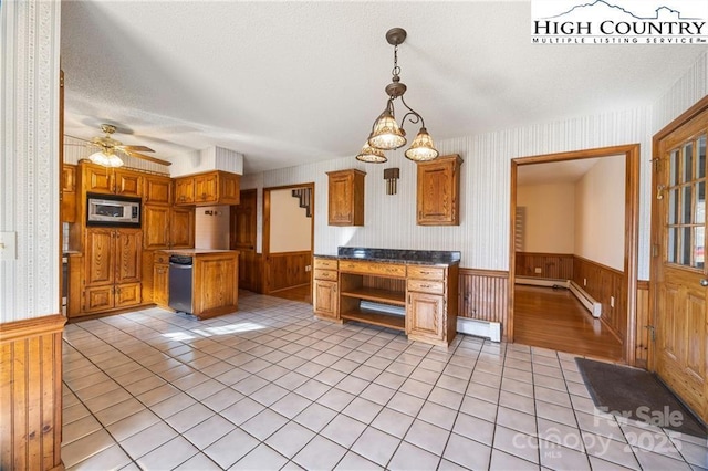 kitchen featuring a wainscoted wall, stainless steel microwave, a baseboard heating unit, and light tile patterned flooring