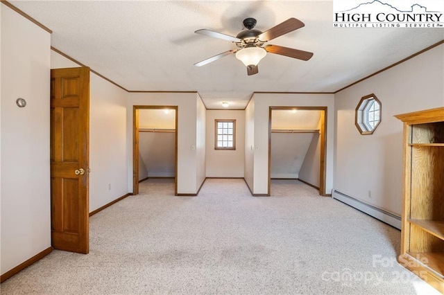 unfurnished bedroom with light carpet, baseboards, ornamental molding, baseboard heating, and multiple closets