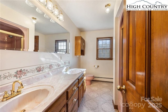 bathroom with plenty of natural light, a baseboard radiator, and a sink